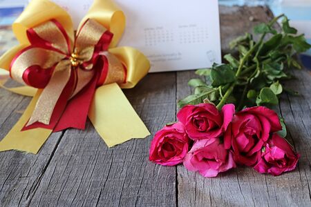 Bouquet of beautiful red roses with ribbon on old wooden background. Valenday's day or wedding conceptの写真素材