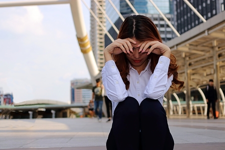 Young businesswoman feeling failure and frustrated with her work. Stressed business concept. Selective focus and shallow depth of field.の写真素材