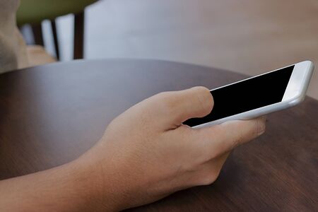 Close up mobile smart phone with blank screen on hands of unidentified people.