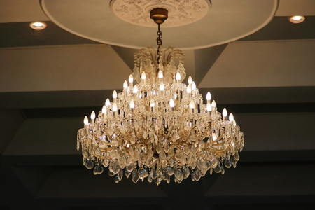Luxury crystal chandelier hanging under ceiling in the room.の写真素材