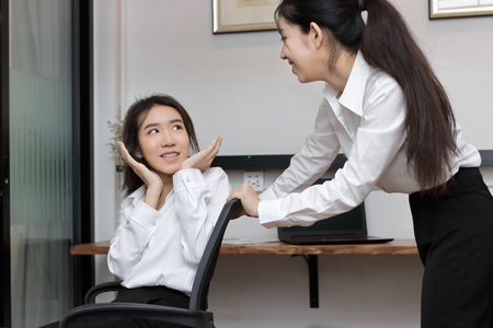 Cheerful young Asian business woman push chair and having fun together in office.の写真素材