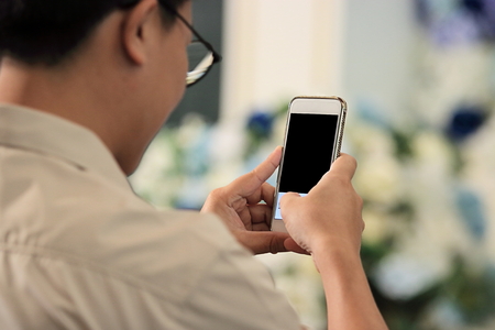 Selective focus on mobile smart phone taking photo with hands of unidentified