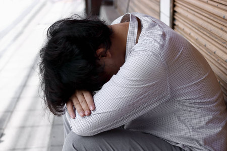 Tired stressed Asian business man bend down the headの写真素材