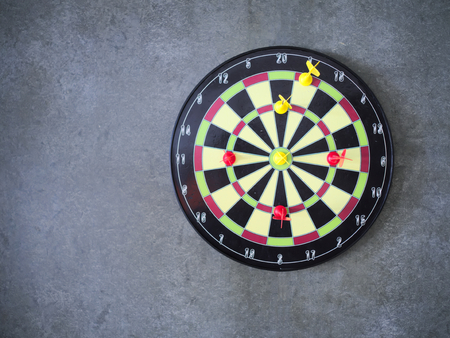 Darts arrow in the dartboard on the black wallの写真素材