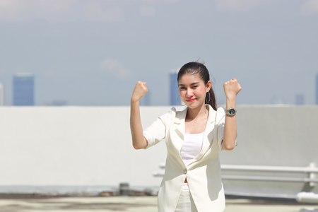 Successful young Asian business woman raising arms.の写真素材