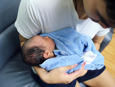 Cute newborn baby sleeping in hands of parents.の写真素材
