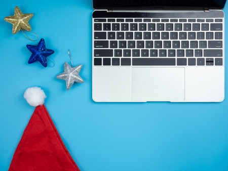 Top view of laptop and Santa hat on blue isolated background.の写真素材