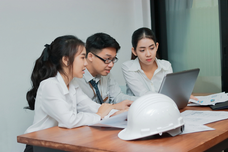 Young Asian people working with laptop together in modern office. Teamwork business concept.の写真素材