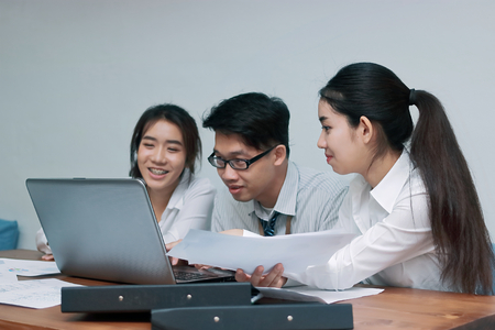 Teamwork business concept. Group of Asian people working with laptop together in modern office. Selective focus and shallow depth of field.の写真素材