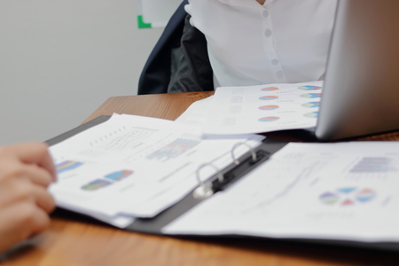 Selective focus and shallow depth of field on charts or paper work on the desk between meeting in...