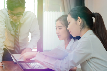 Teamwork business concept. Group of Asian people working with laptop together in modern office. Selective focus and shallow depth of field.の写真素材