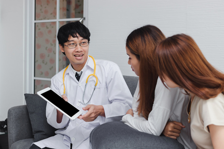 Young Asian male doctor consulting patient in hospital office. Health care and medical concept.の写真素材
