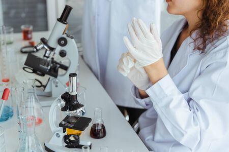 Scientist wearing a medical glove in modern biological laboratory.