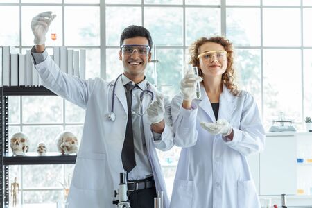 Young successful scientist performing an experiment in modern chemical laboratory. Science research healthcare happiness conceptの写真素材