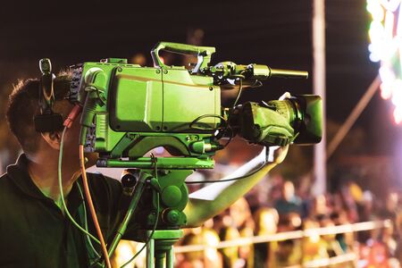 Professional digital video camera technician. Videographer with equipment at event.の写真素材