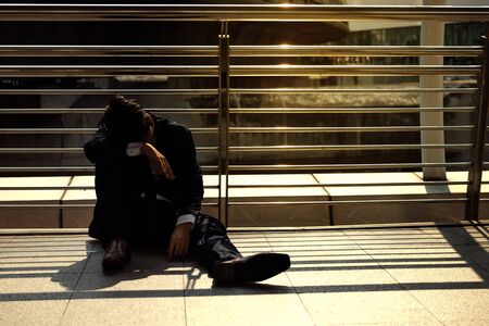 Tired upset young Asian business man suffering from severe depression. Unemployment , jobless and layoff concept.の写真素材