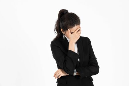 Exhausted upset Asian business woman with hands on face suffering from severe depression on white isolated background. Unemployment and layoff concept.の写真素材