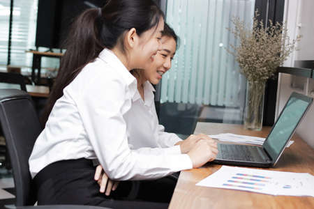 Happy smiling young Asian business woman working together with colleagues in the office. Business...