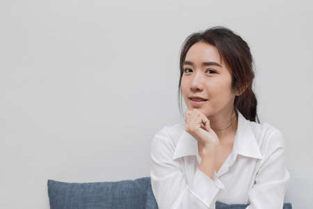 Happy smiling young Asian woman having idea posing in living room.
