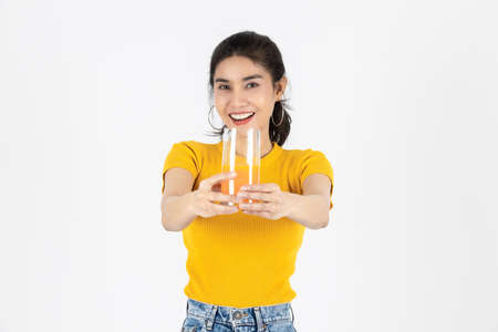Beauty young Asian woman showing glass of orange juice over white isolated background. Lifestyle, Diet, Healthy and clean food concept.の写真素材