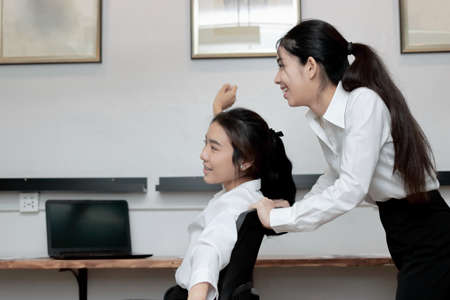Cheerful young Asian business people having fun with chairs in the office. Happy business team concept.の写真素材