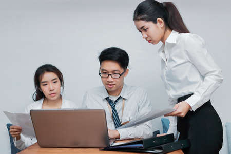 Group of young Asian business people working together in the office. Business teamwork cooperation...