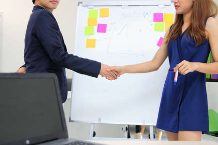 Success Asian business female shaking hands with partners after finishing a meeting. Handshake greeting deal concept.の写真素材