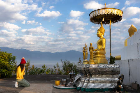 Beautiful young Asian woman traveler tourist respect and praying the old Buddha statue at Phrae, Thailand. Journey travel concept.の写真素材