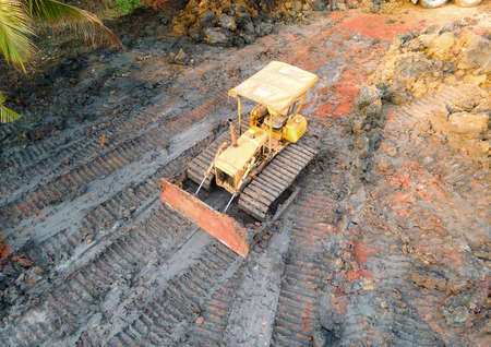 Heavy yellow bulldozer leveling ground at construction site.の写真素材