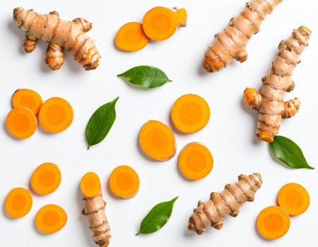 Fresh turmeric with slices and leaves on white background, top viewの素材