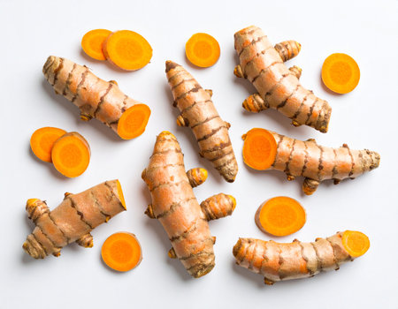Fresh turmeric root and sliced carrot on white background, top viewの素材