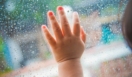 Rain drops on the car window and children hand . Abstract backgroundの写真素材