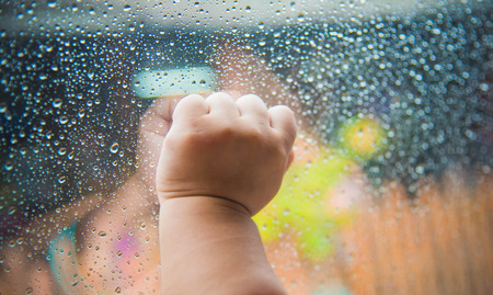 Rain drops on the car window and children hand . Abstract backgroundの写真素材
