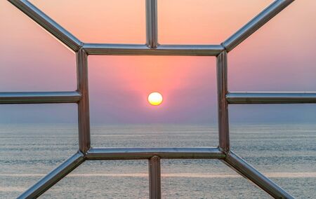 sunset between the aluminum pole frame in the seaの写真素材