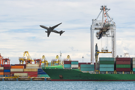 Container Cargo freight ship with working crane loading bridge in shipyard at Blue sky for Logistic...