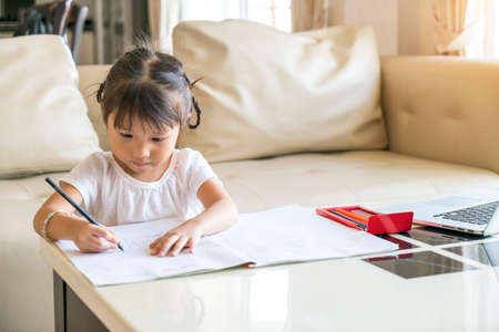 little cute girl do her homework at homeの写真素材