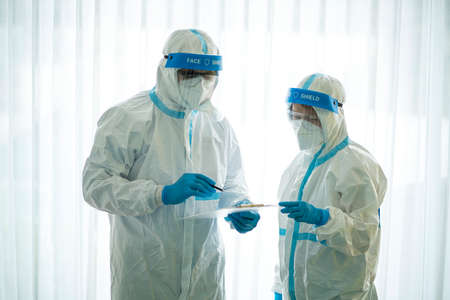 Asian doctor holding checking coronavirus or covid-19 infected patient name list sheet in quarantine...