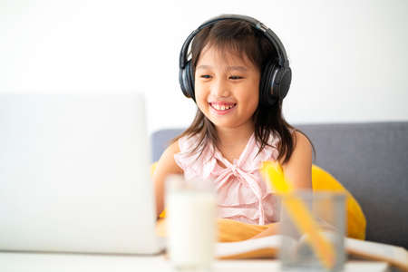 A girl using a laptop to do her homeworkの写真素材