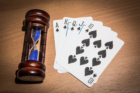 Poker and hourglass on  wooden floor.