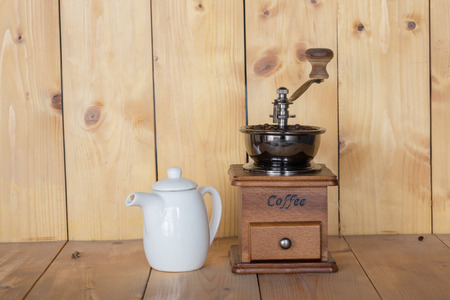 Vintage coffee grinder and jar of sweet water.on wooden background.の写真素材