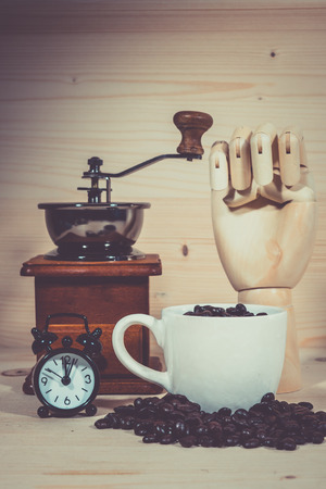 Coffee cup Clock  Alarm  Coffee cup full of coffee beans with on wooden deskの写真素材