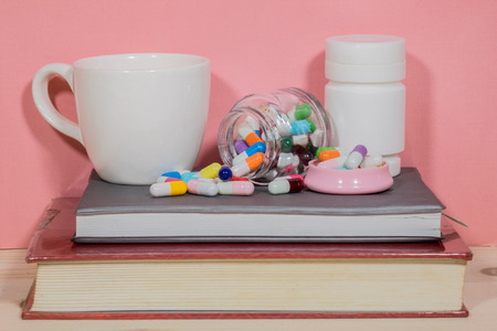 Books Pills. Medicine and health books on a wood table.の写真素材