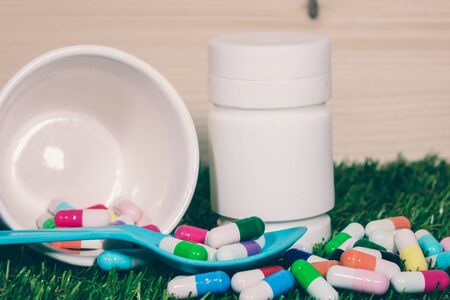 Capsules and pills on grass background ,Maintain health from many causes.