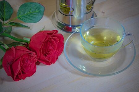 Red roses and aromatic tea in the afternoon to refresh your eyes on Wood Backgroundの写真素材