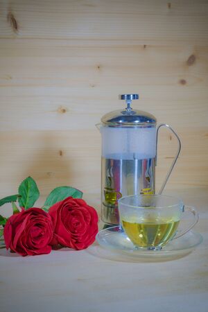 Red roses and aromatic tea in the afternoon to refresh your eyes on Wood Backgroundの写真素材