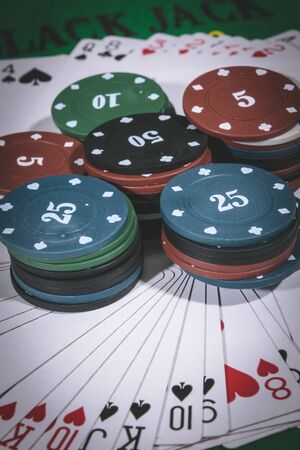 Person playing poker and looking at cards , risk game poker table during a game. Chips, money and cards on the table.の写真素材