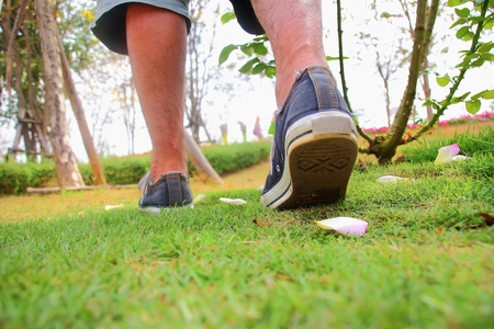 People wearing white sneakers are moving in the grassの写真素材