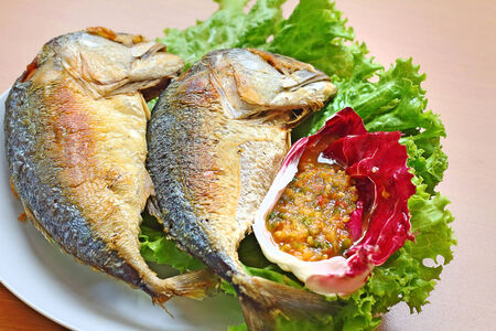 Fried Mackerel and Spicy sauce in plate on wooden table