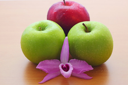 apples and  purple orchid on the wooden tableの写真素材