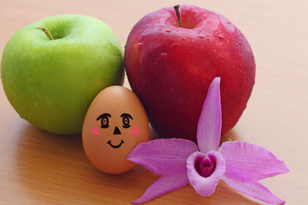Apples ,Egg and purple orchid on the wooden tableの写真素材